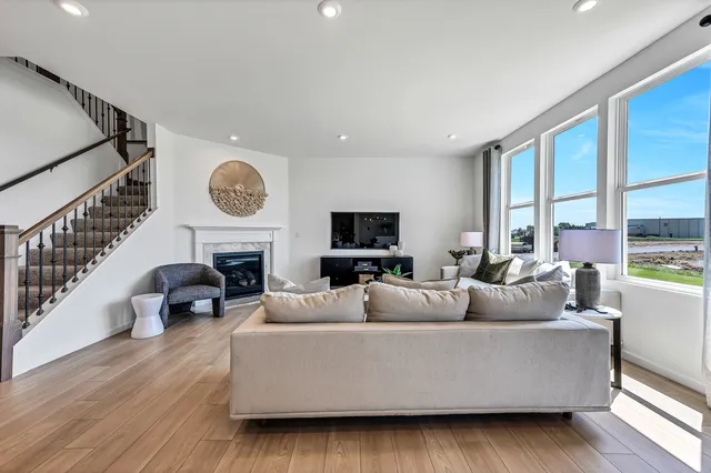 a living room with fireplace furniture and a large window