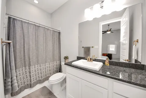a bathroom with a double vanity sink toilet and shower