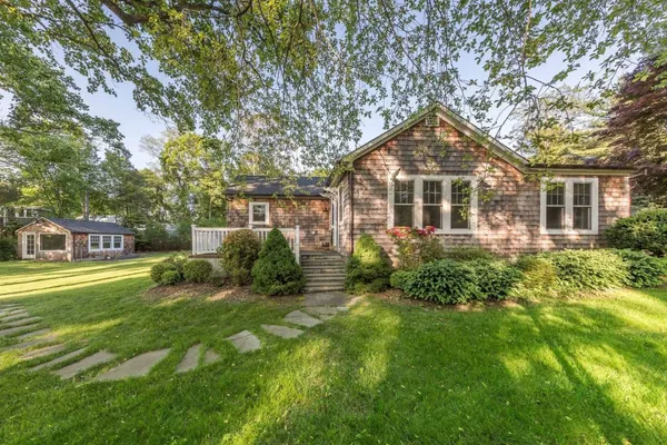 a front view of a house with a yard and trees