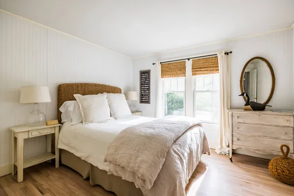 a bedroom with a bed and a dresser next to a window