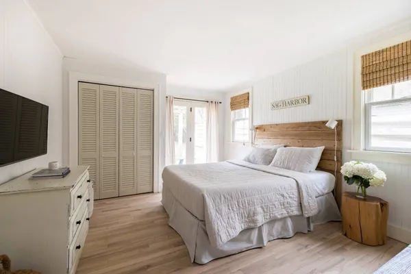a bedroom with a bed and a flat tv screen on a dresser