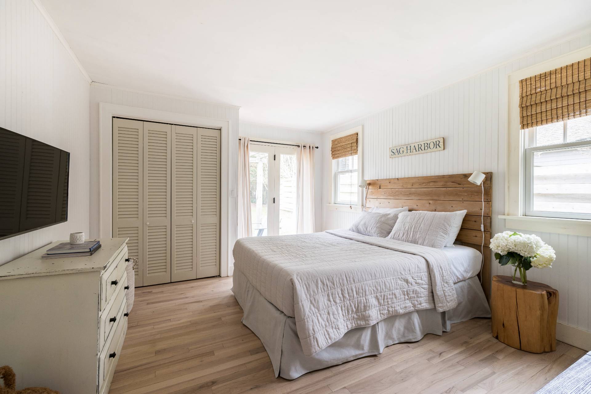 Undisclosed Address Sag Harbor, NY 11963 - Photo 7 of 14 a bedroom with a bed and a flat tv screen on a dresser