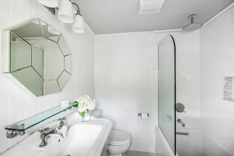 a bathroom with a sink a toilet and shower