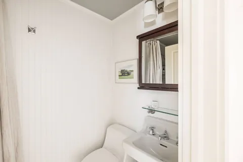 a bathroom with a toilet sink and mirror
