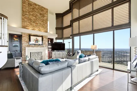 a living room with furniture a flat screen tv and a large window