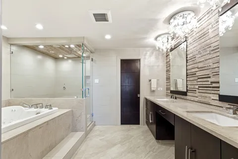 a bathroom with a granite countertop sink a large mirror and a bathtub