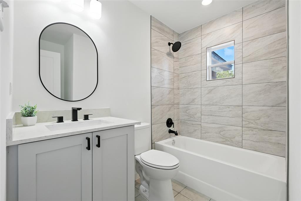 3122 Seevers Avenue Dallas, TX 75216 - Photo 12 of 16 a bathroom with a toilet a sink a mirror and bathtub