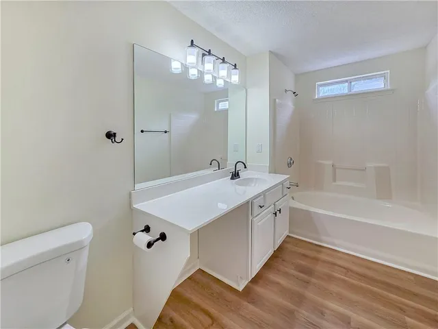 a spacious bathroom with a granite countertop sink a toilet and shower