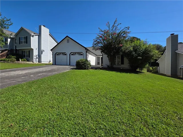 a view of a house with yard and a tree