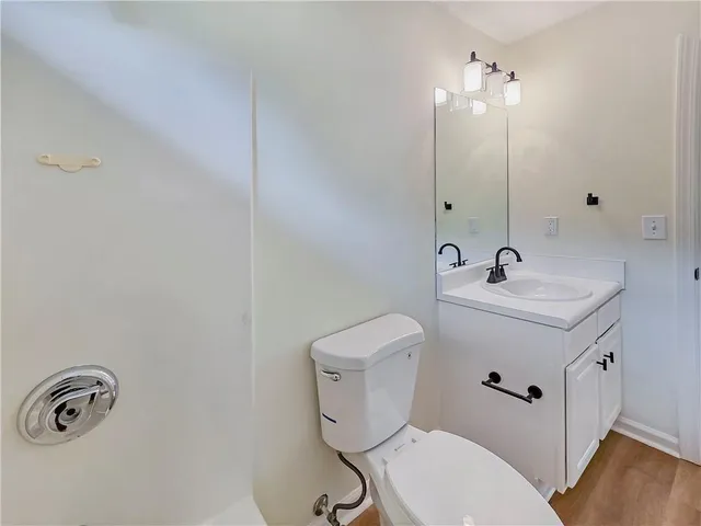 a bathroom with a toilet a sink and mirror