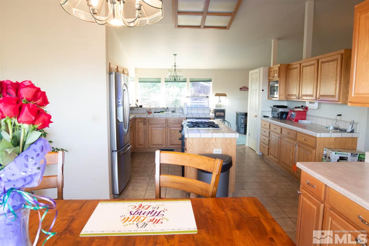 4080 Rancheria Road Fallon, NV 89406 - Photo 11 of 25 a kitchen with stainless steel appliances kitchen island granite countertop a refrigerator dining table and chairs