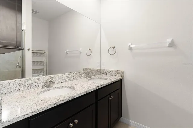 a bathroom with a granite countertop sink and a mirror