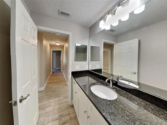 a bathroom with a granite countertop double vanity sink and a mirror