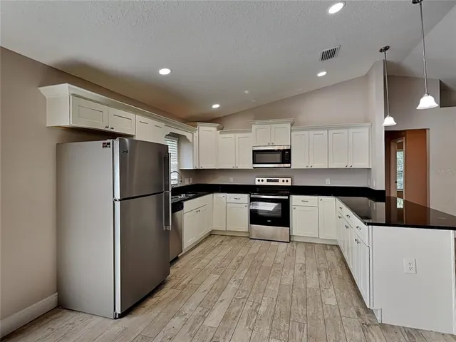 a kitchen with stainless steel appliances a refrigerator sink and microwave
