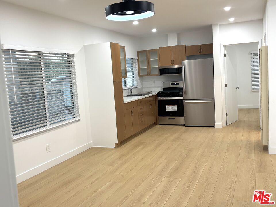2115 Venice Blvd., Unit 1/2 Los Angeles, CA 90006 - Photo 3 of 14 a kitchen with stainless steel appliances a refrigerator and a stove top oven