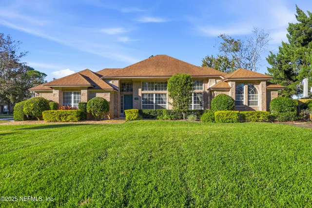 a front view of a house with a yard and potted plants