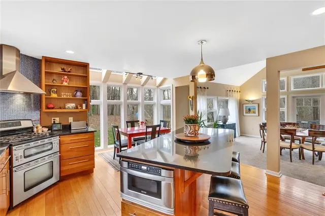 a kitchen with stainless steel appliances a stove and a wooden floor