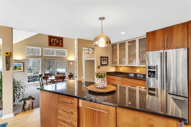 a kitchen with stainless steel appliances granite countertop a sink refrigerator and cabinets