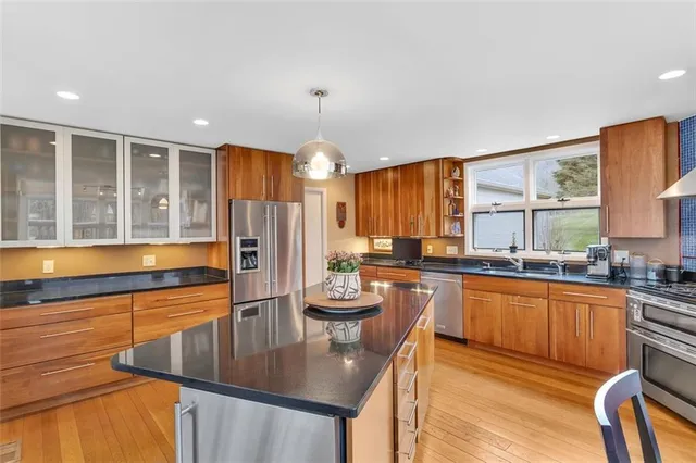 a kitchen with stainless steel appliances granite countertop a sink stove and refrigerator