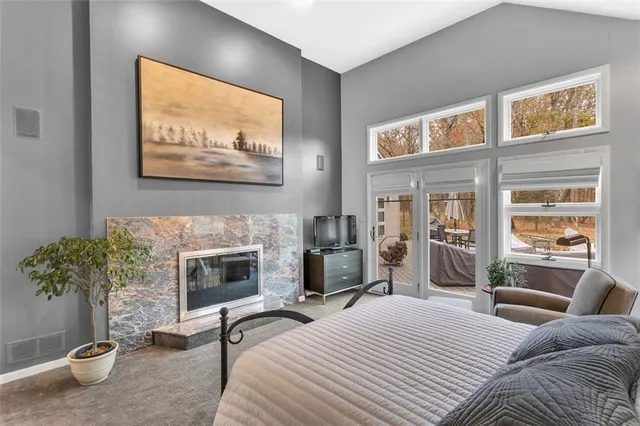 a bedroom with furniture a fireplace and a flat screen tv