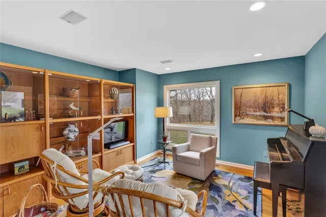 a living room with furniture a flat screen tv and a floor to ceiling window