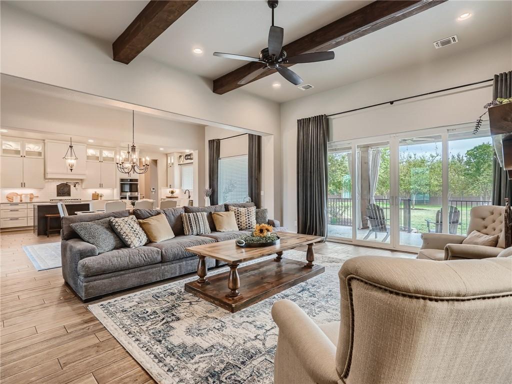 132 Huerta Road Florence, TX 76527 - Photo 6 of 40 An inviting open-concept living space with rustic wood beams, flowing into a gourmet kitchen and a bright patio.