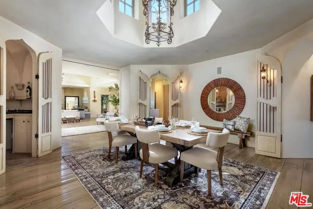 a dining room with wooden floor a glass table and chairs