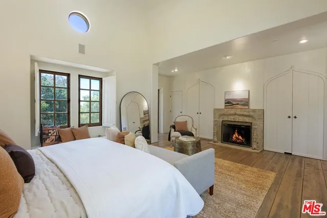 a large bedroom with bed and a fireplace