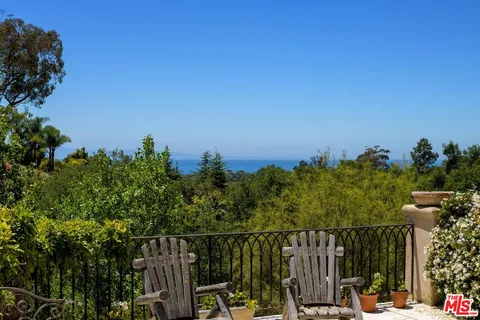 a view of a balcony with two chairs and a table