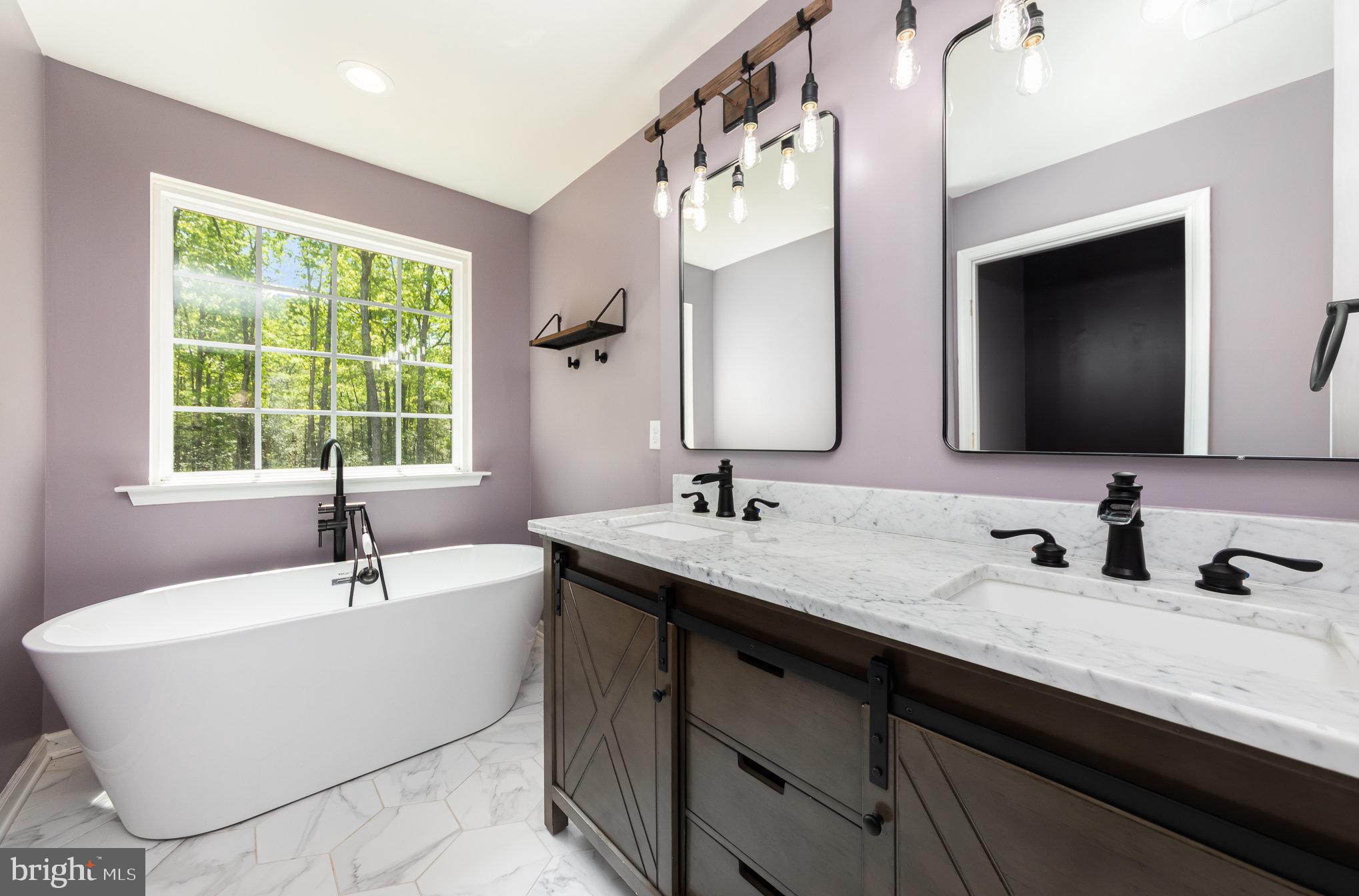 7464 Cedar Fork Road Ruther Glen, VA 22546 - Photo 9 of 24 a bathroom with a double vanity sink a mirror and a window