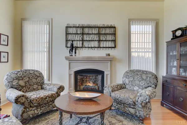 a living room with furniture a bookshelf and a window