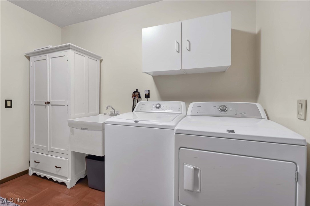 10778 Gate Post Road Strongsville, OH 44149 - Photo 22 of 40 Laundry room featuring wood-type flooring, separate washer and dryer, and cabinets