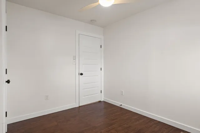 an empty room with a window and wooden floor
