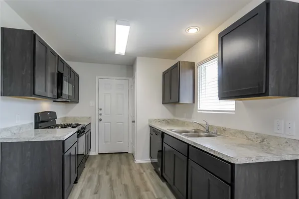 a kitchen with a sink stove and microwave