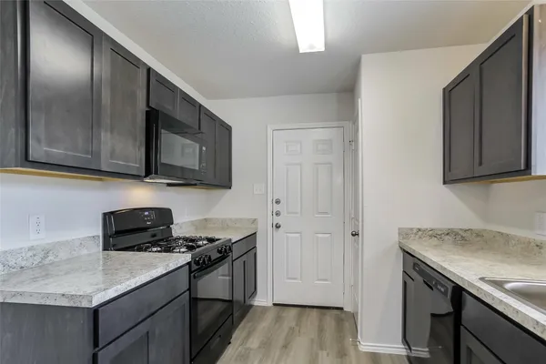 a kitchen with stainless steel appliances granite countertop a sink stove and microwave