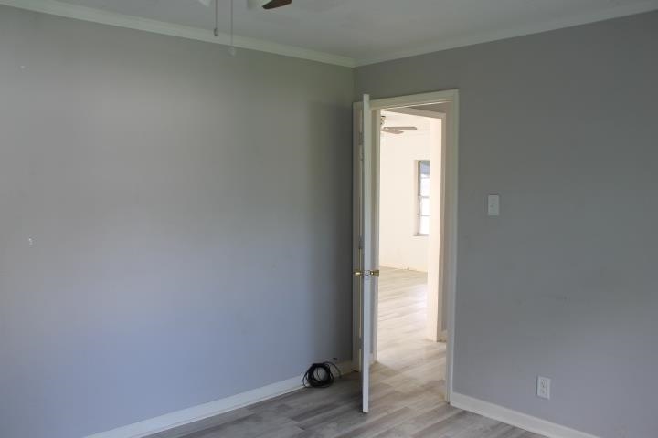 875 Woodrow Street Silsbee, TX 77656 - Photo 27 of 30 a view of an empty room with wooden floor and a window