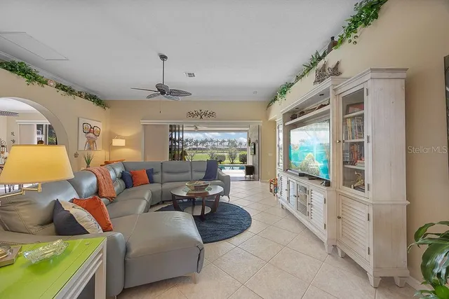 a living room with furniture large window and flat screen tv