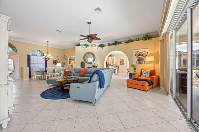 a living room with patio furniture and a chandelier