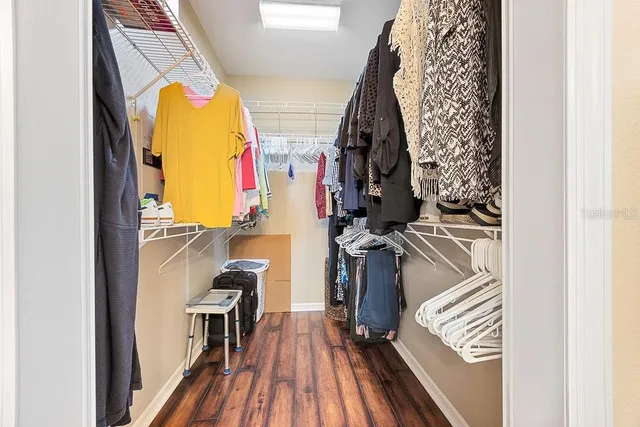 a view of walk in closet with clothes and shoes