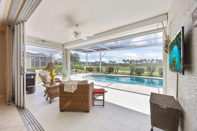 a living room with patio furniture and a floor to ceiling window