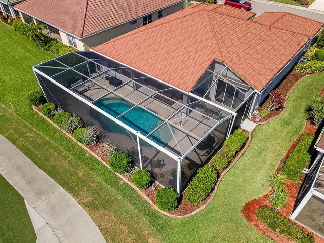 a view of a big house with a big yard and large trees