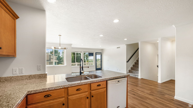 Kitchen island with a double basin sink, modern faucet, and granite-style countertop