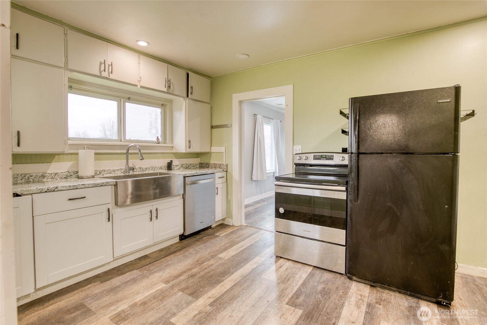 1319 West 2nd Street Aberdeen, WA 98520 - Photo 6 of 25 a kitchen with granite countertop a refrigerator and a stove top oven