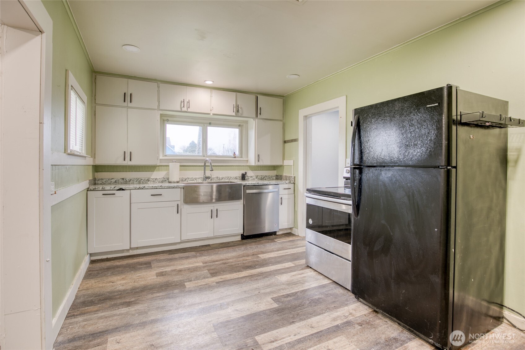 1319 West 2nd Street Aberdeen, WA 98520 - Photo 7 of 25 a kitchen with white cabinets stainless steel appliances and window