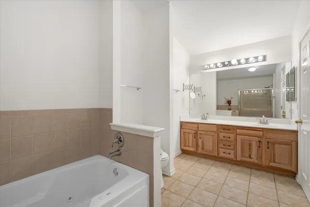 a spacious bathroom with a tub sink and mirror