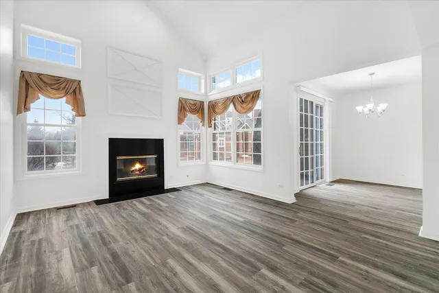 a view of empty room with wooden floor and fireplace