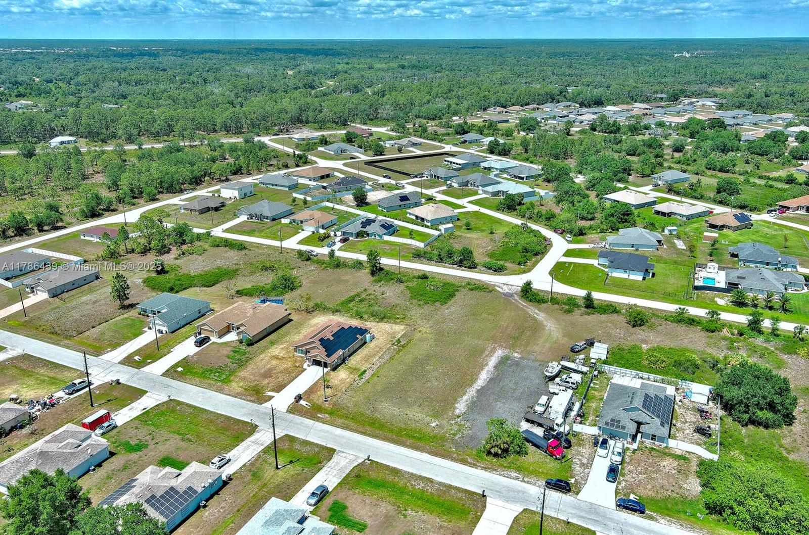 548 Windermere Drive Lehigh Acres, FL 33972 - Photo 17 of 26 an aerial view of residential houses with outdoor space and trees