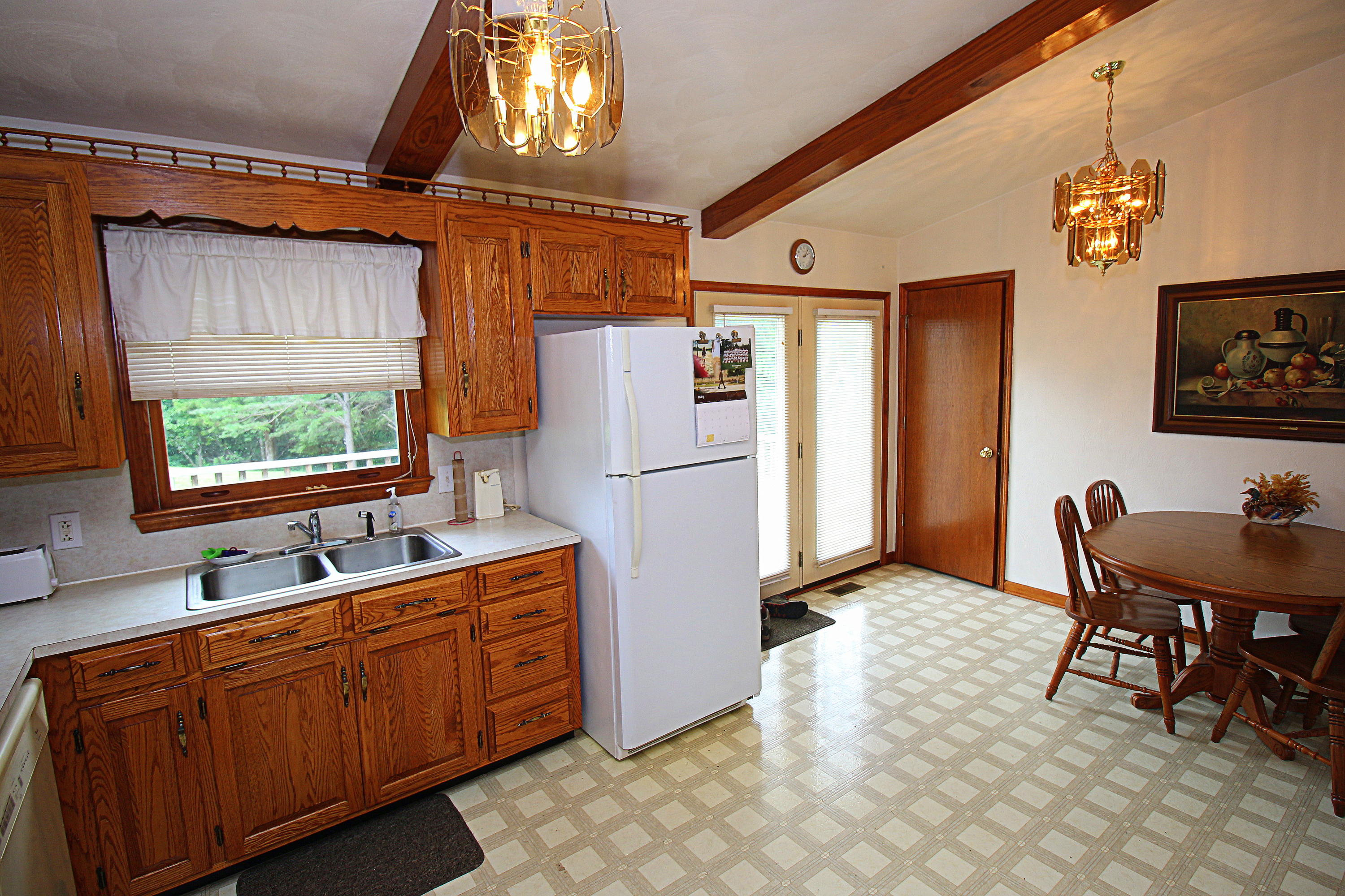 2785 Quarles Road Thaxton, VA 24174 - Photo 8 of 37 a kitchen with stainless steel appliances granite countertop a refrigerator a sink dishwasher a stove a dining table and chairs with wooden floor