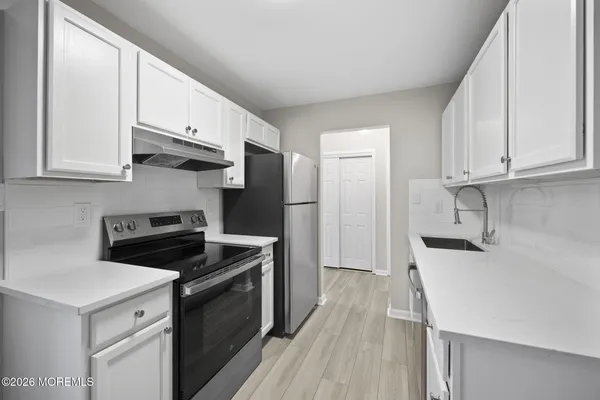 a kitchen with stainless steel appliances a stove microwave and refrigerator