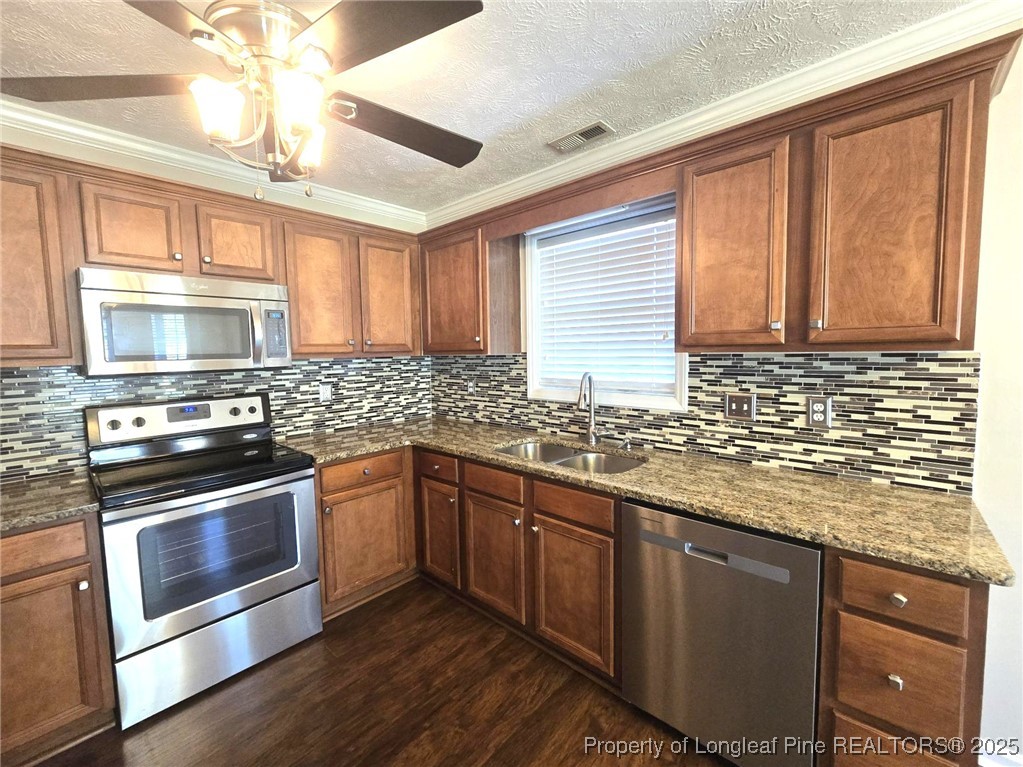 1540 Clan Campbell Drive Raeford, NC 28376 - Photo 11 of 35 a kitchen with stainless steel appliances granite countertop wooden cabinets granite counter tops and a window
